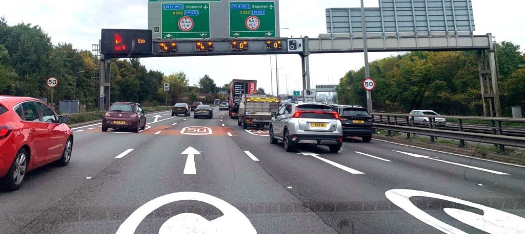 Approach to Dartford tunnel crossing with C-charge sign on road just visible
