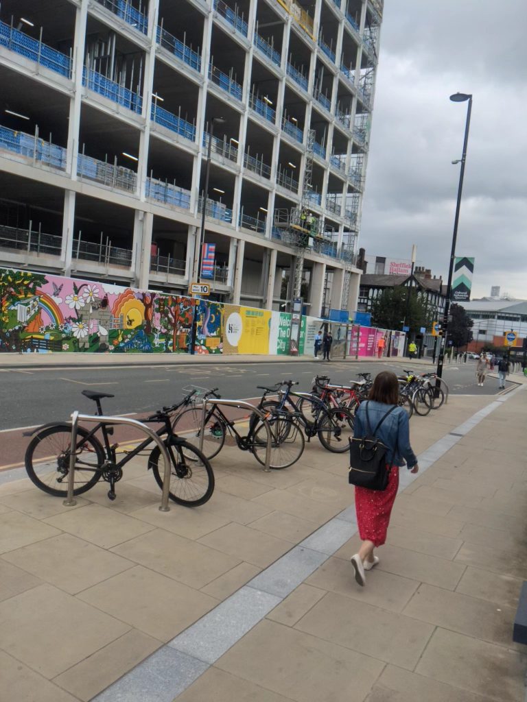 Person walking past cycles parked, Sheffield 2023